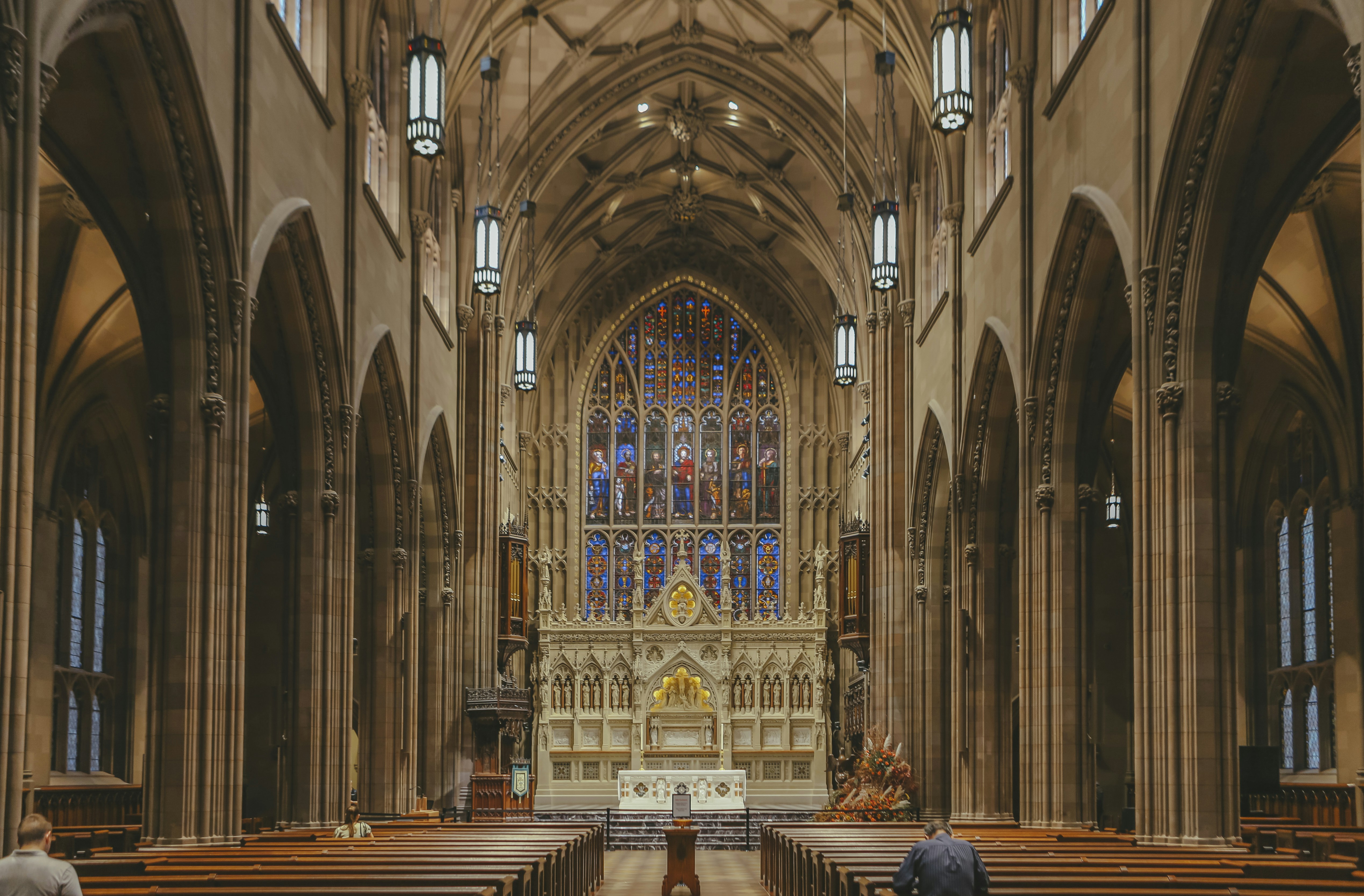 a large cathedral with pews and stained glass windows