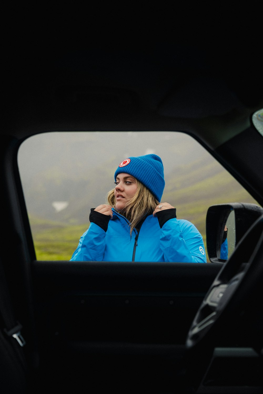 a woman in a blue jacket talking on a cell phone