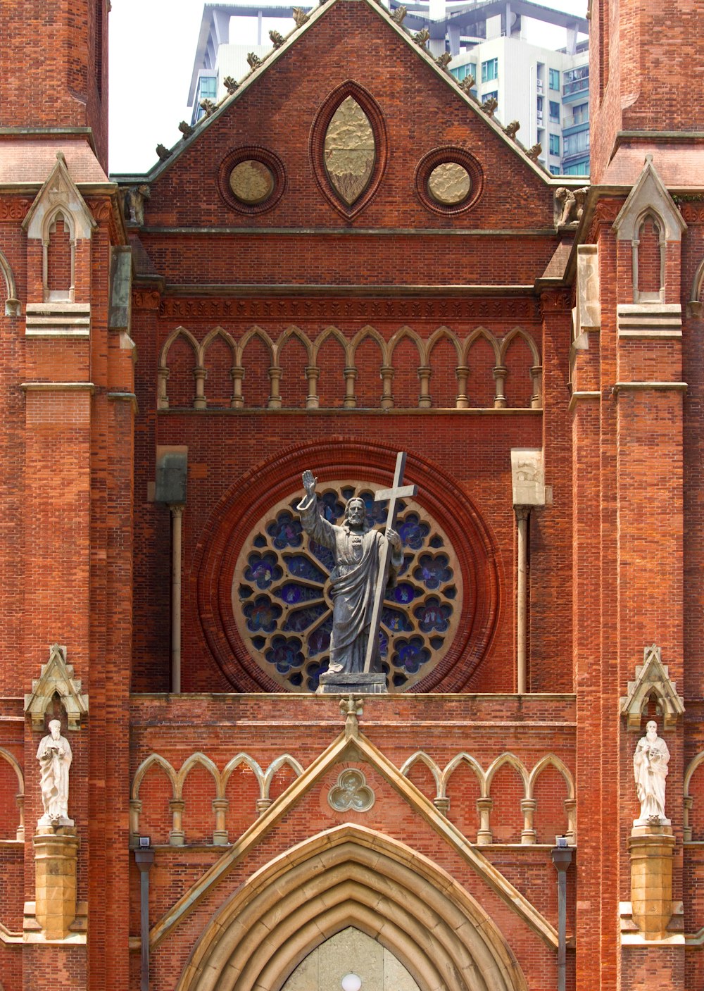 a church with a statue of a woman holding a cross