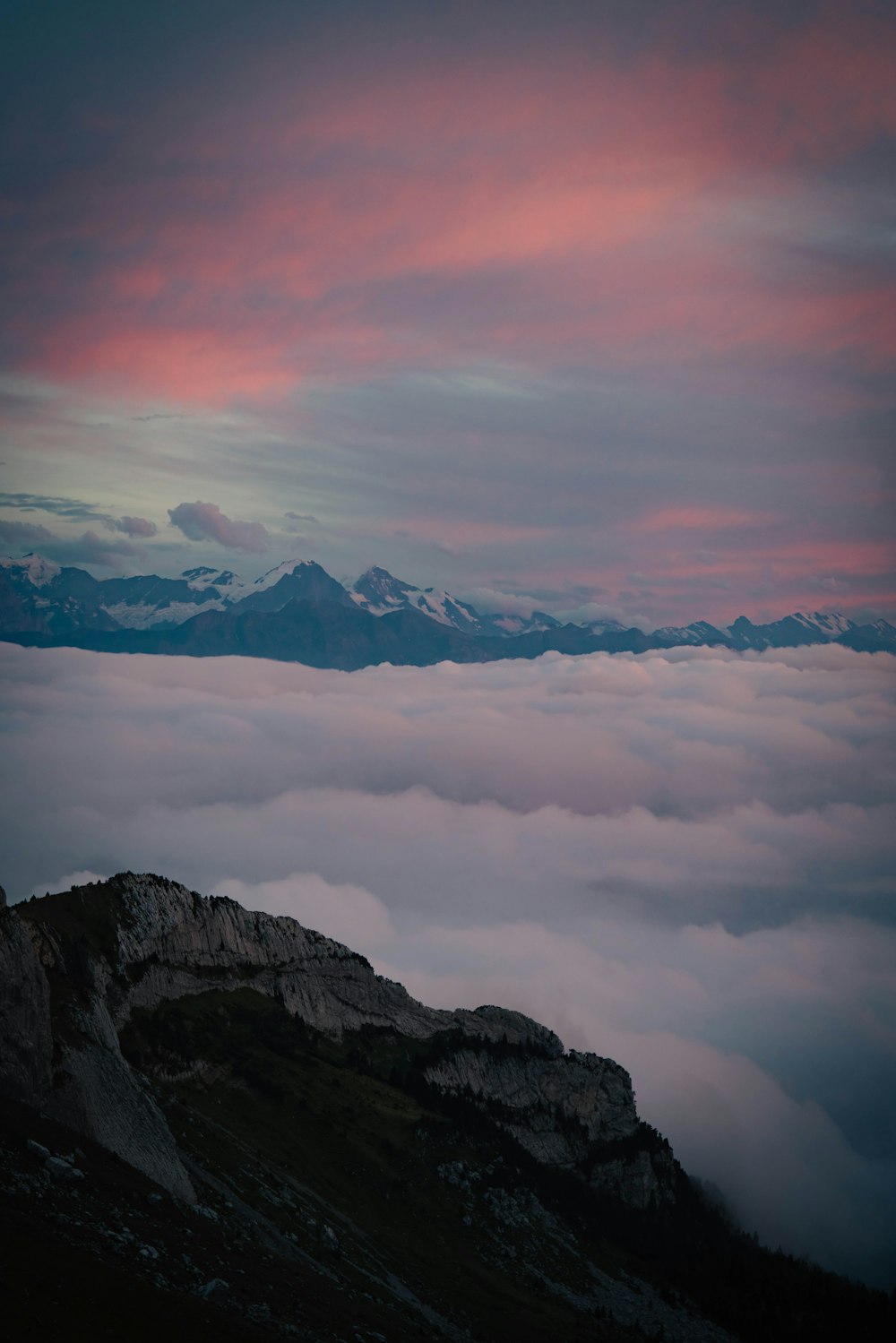 a view of the mountains and clouds from the top of a mountain