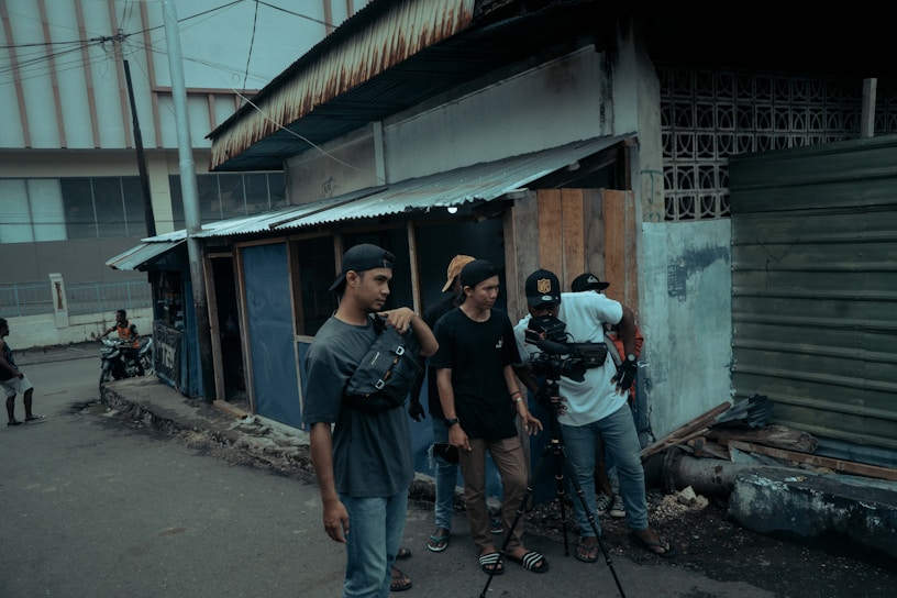 A vibrant film crew setting up a camera on a colorful Colombian street at golden hour.