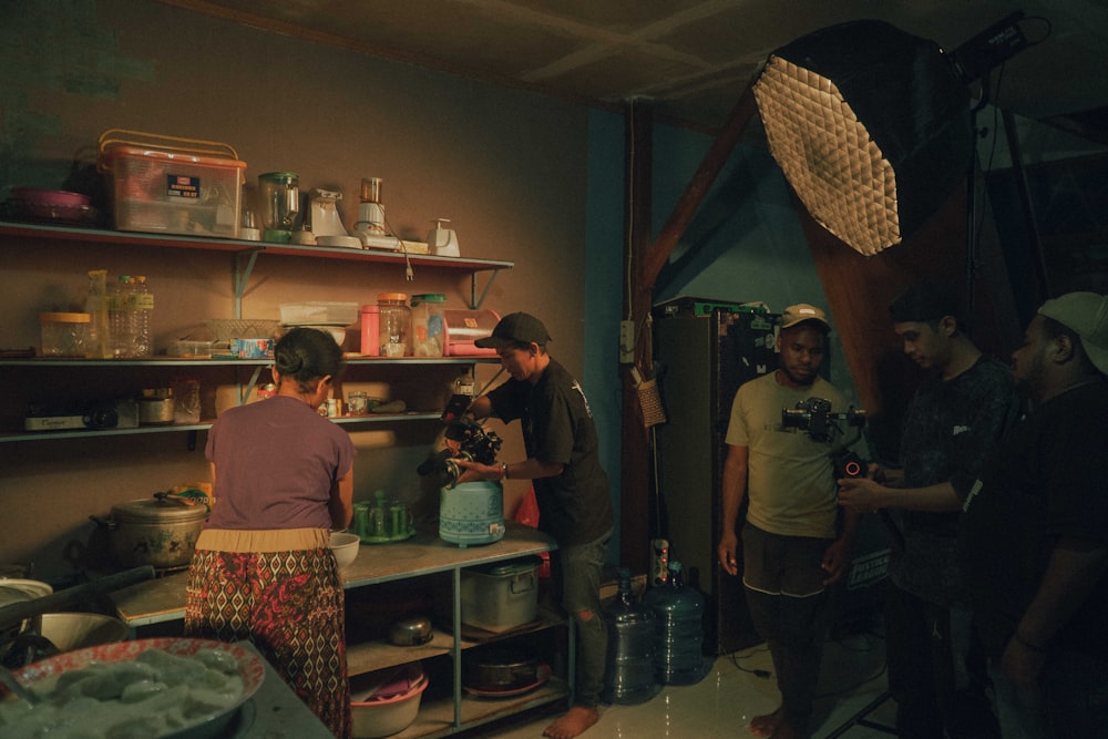 a group of people standing around a kitchen