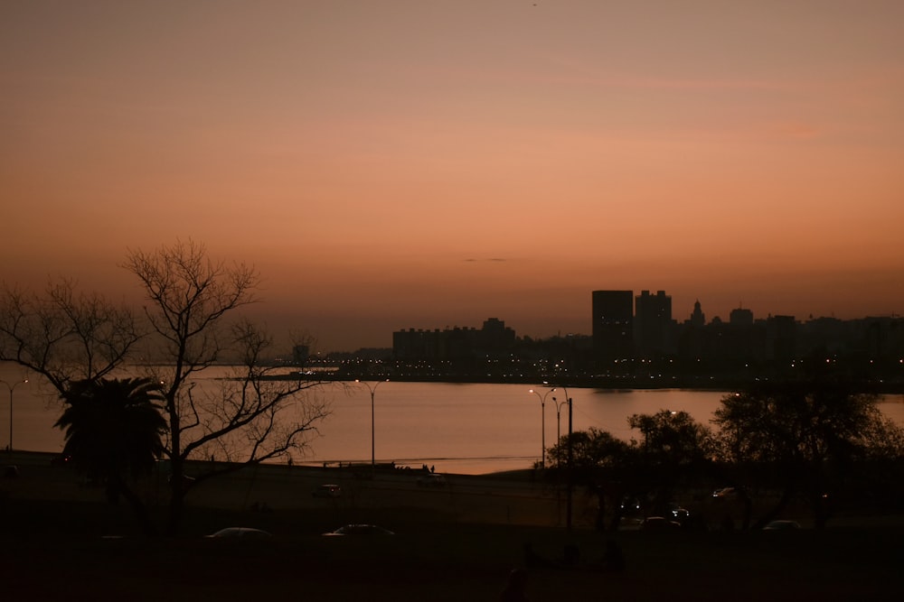 a sunset view of a body of water with a city in the background