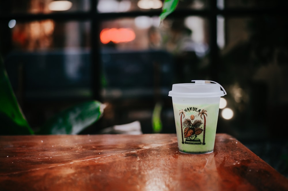 a cup of coffee sitting on top of a wooden table