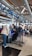 A busy airport check-in area with passengers lining up at the counters. People are handling their luggage, and there are various signs displaying flight information. The environment is crowded, with many travelers preparing for their flights.
