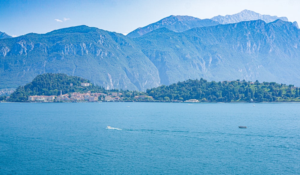 a boat in a large body of water with mountains in the background