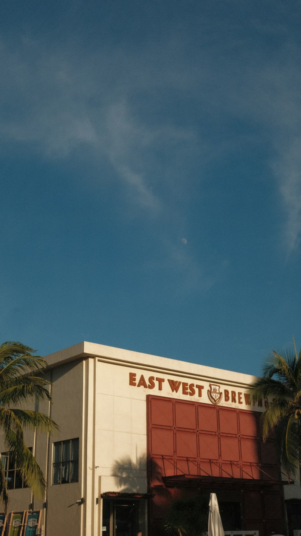 a red and white building with a palm tree in front of it