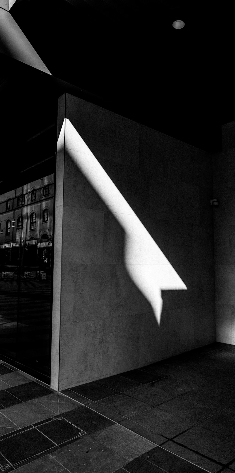 a black and white photo of the shadow of a building