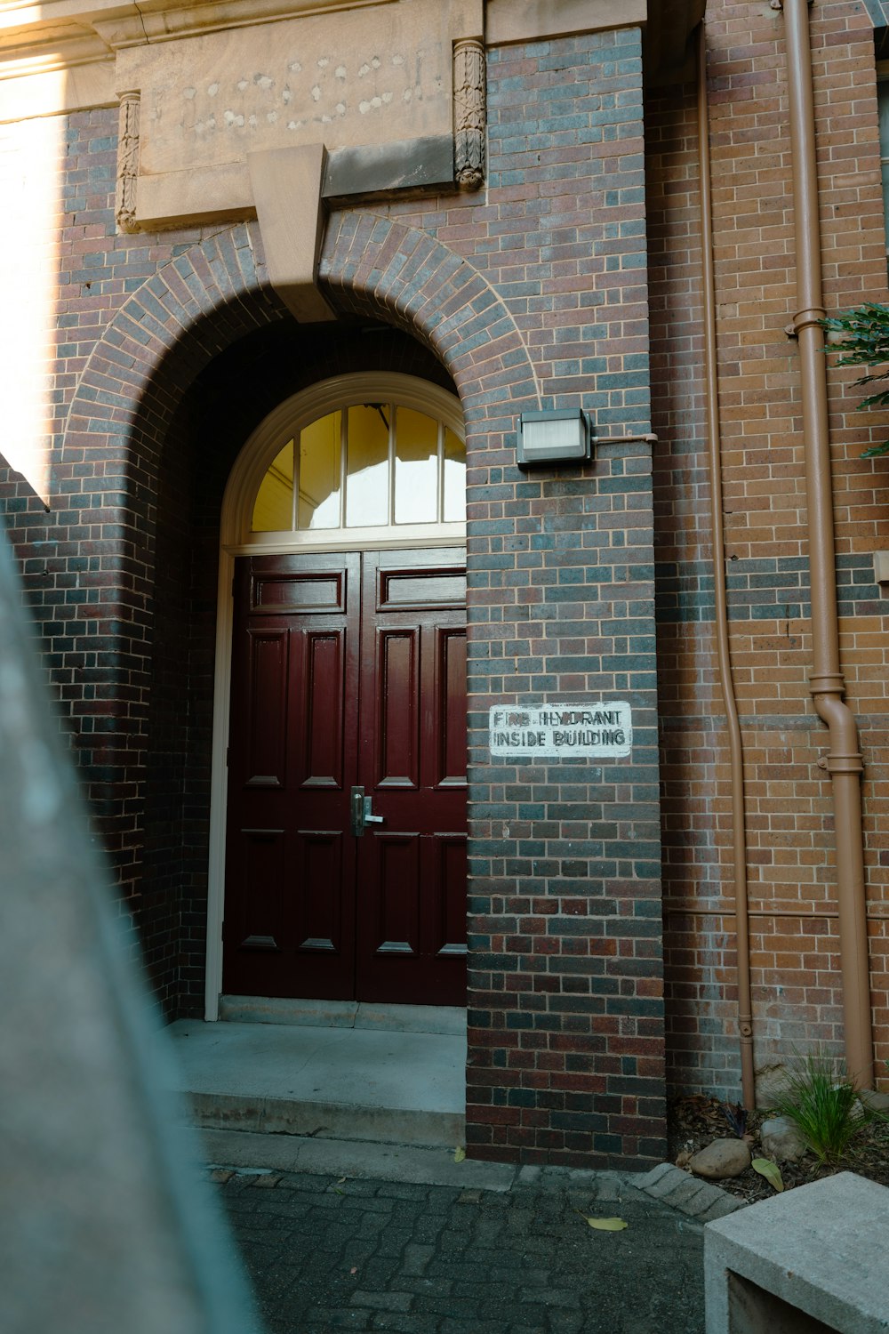 a brick building with a red door and arched doorway