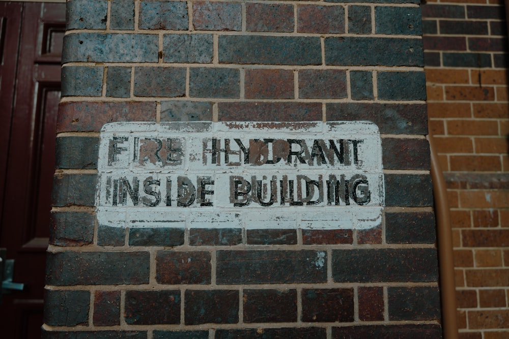 a fire hydrant inside building sign on a brick wall