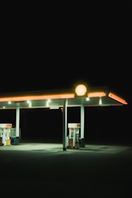 a gas station at night with a light on