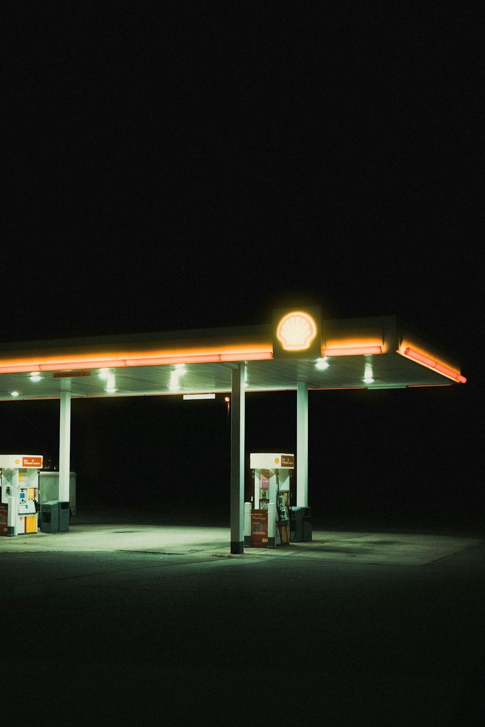a gas station at night with a light on