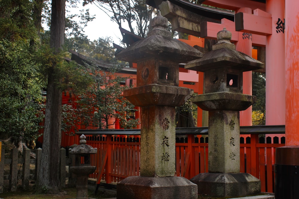 a couple of stone pillars sitting in front of a red building