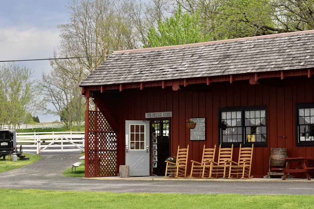 a small red building with chairs outside of it