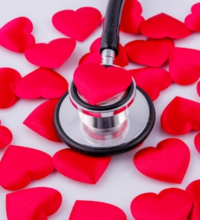a stethoscope surrounded by hearts on a white surface