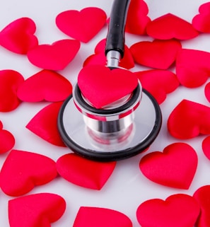 a stethoscope surrounded by hearts on a white surface