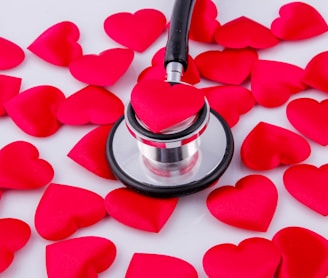 a stethoscope surrounded by hearts on a white surface