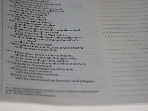 A close-up view of a page from a book with text formatted in a poetic or biblical style, featuring numbered verses and indented lines. The text discusses themes of wrath and consequences.