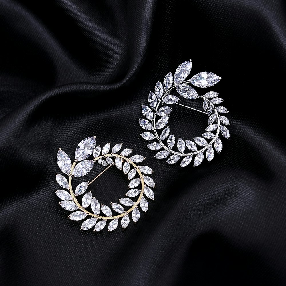 a pair of earrings sitting on top of a black cloth