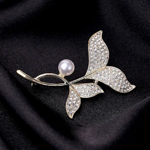 Embellished crystal pin pinned to a silk scarf, capturing the shimmer and fine craftsmanship