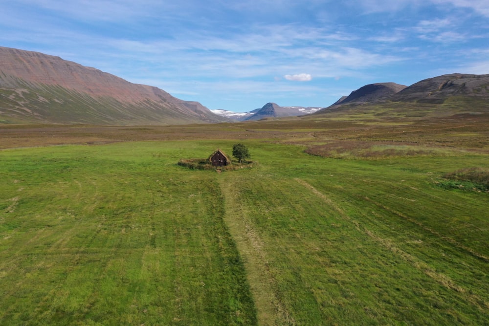 an aerial view of a field with a house in the middle