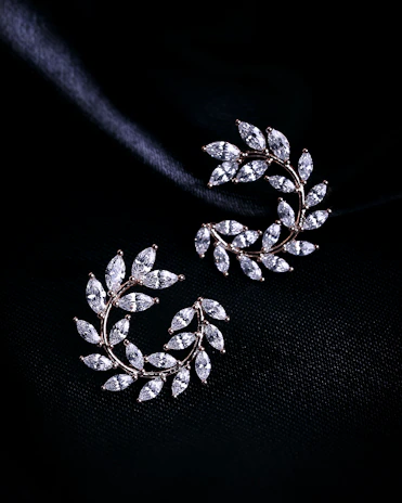 a pair of earrings on a black background