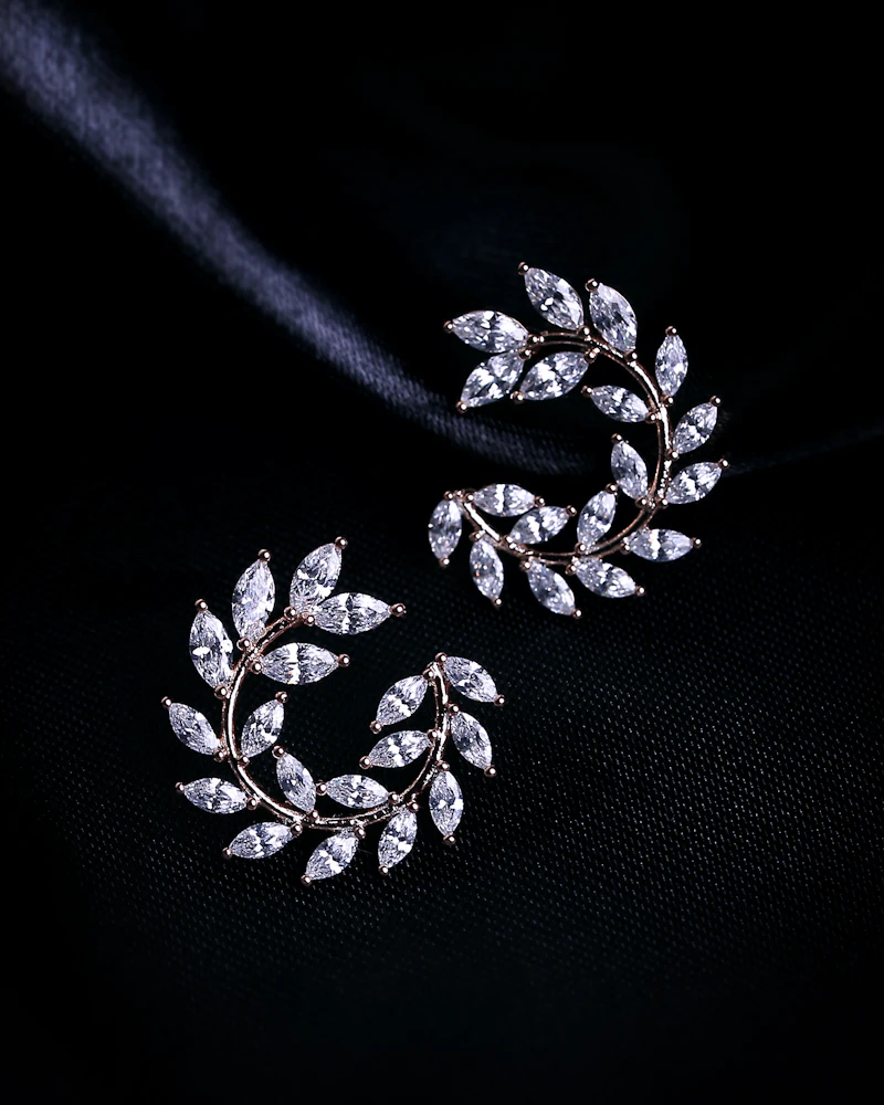 Diamond leaf ear climbers shaped like palm fronds on black satin