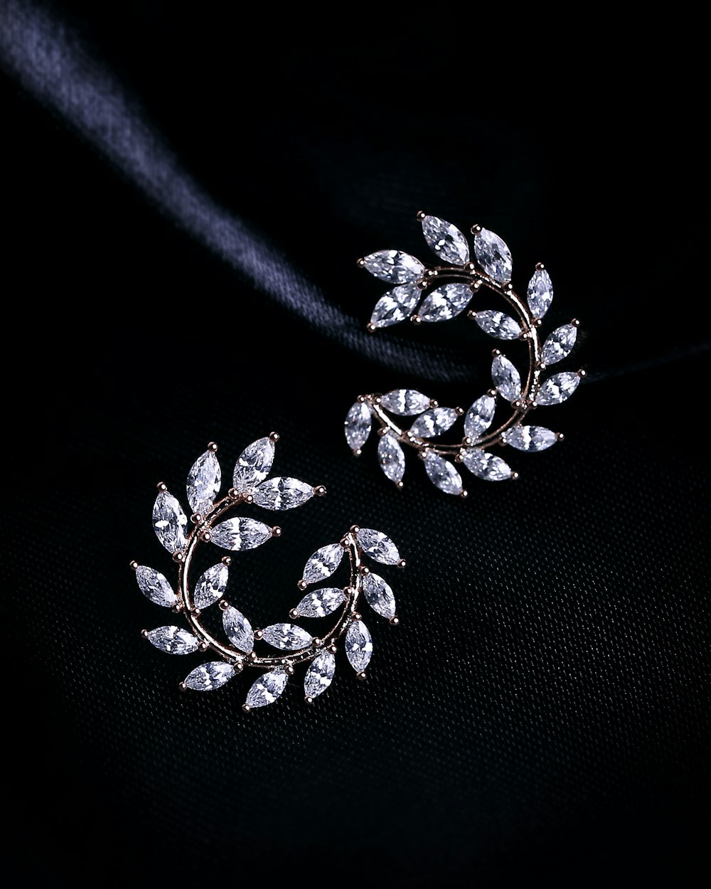 a pair of earrings on a black background