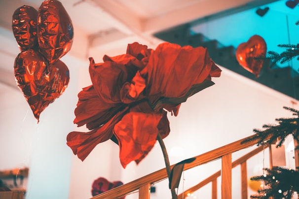 A cozy room decorated for a proposal, featuring a heart-shaped arrangement of red roses.