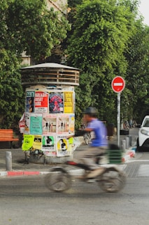 a man riding a bike down a street next to a traffic light