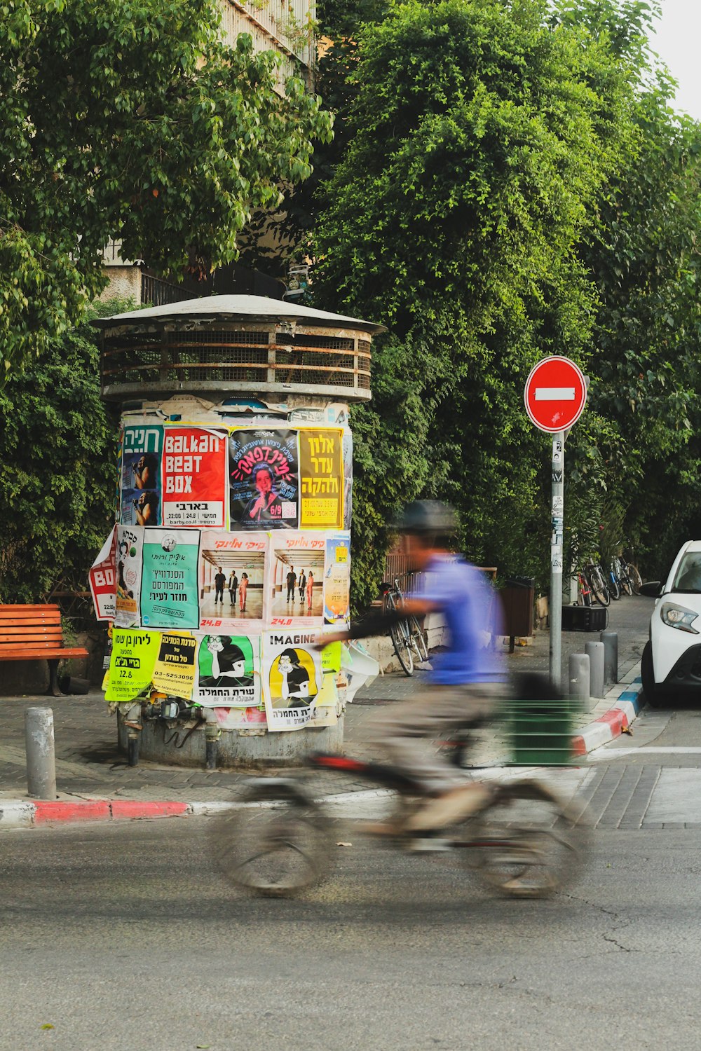 a man riding a bike down a street next to a traffic light