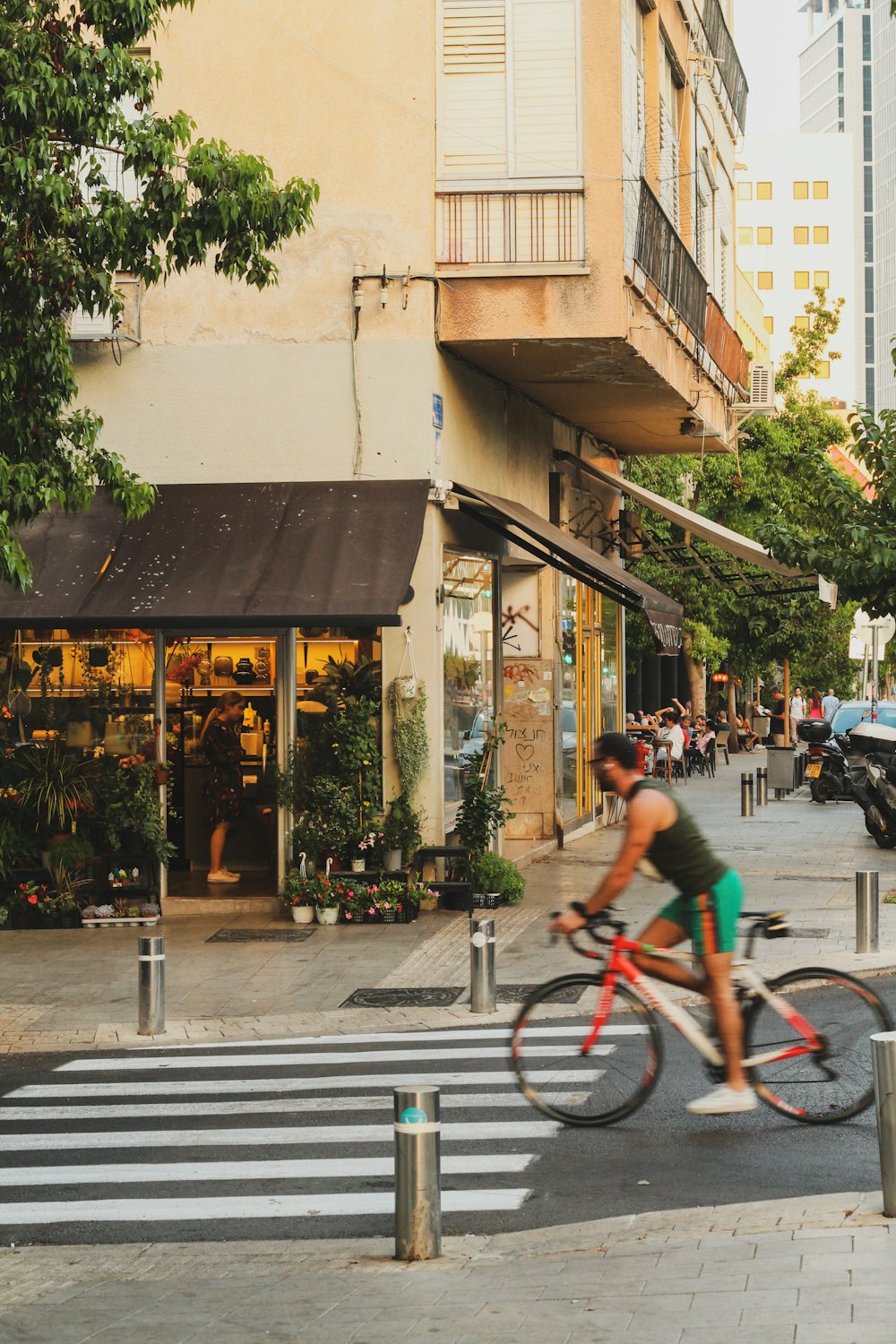 a man riding a bike down a street next to a cross walk