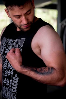 a man with a tattoo on his arm holding a cell phone