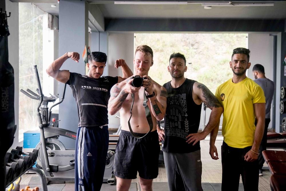 a group of men standing next to each other in a gym