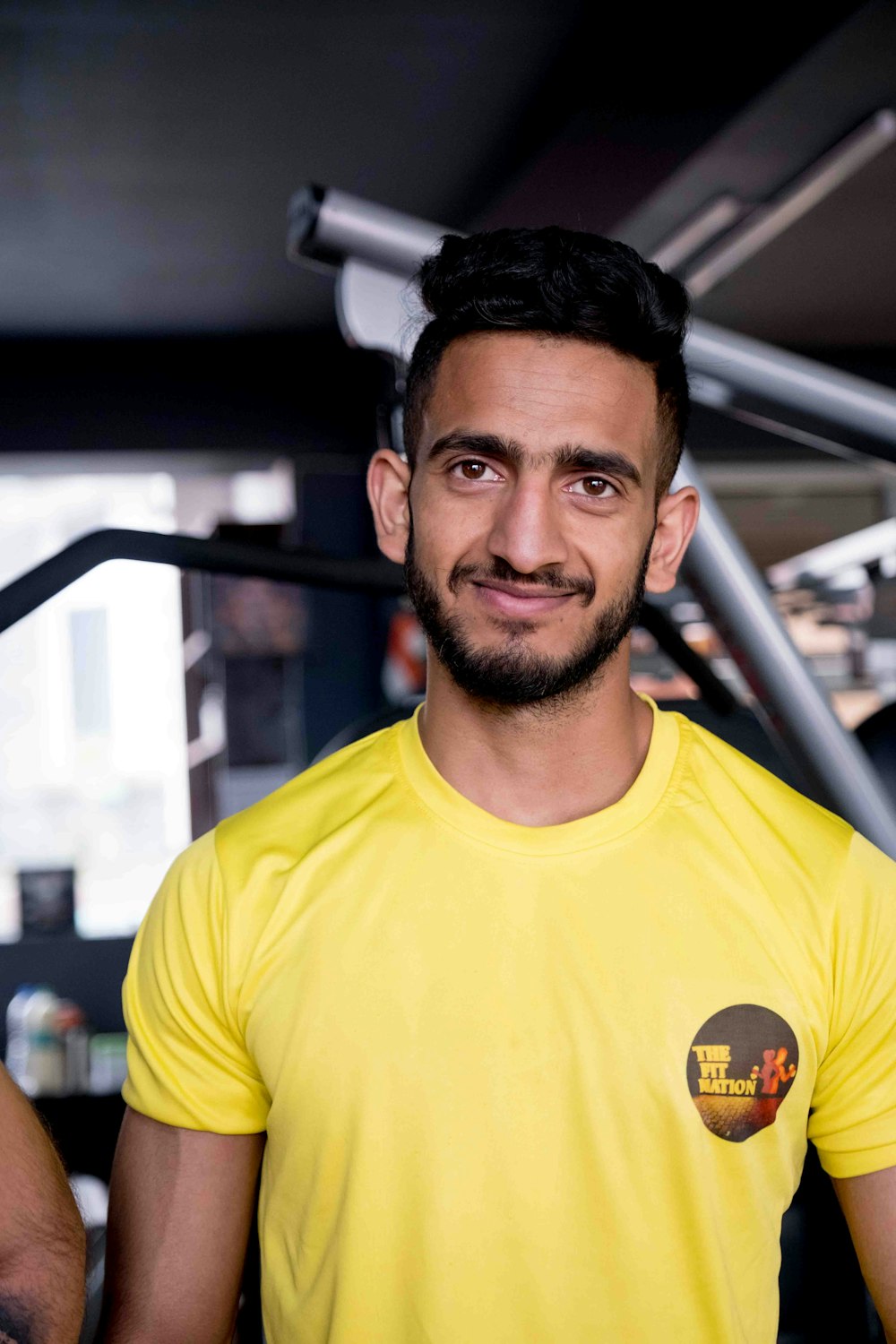 a man in a yellow shirt standing in a gym