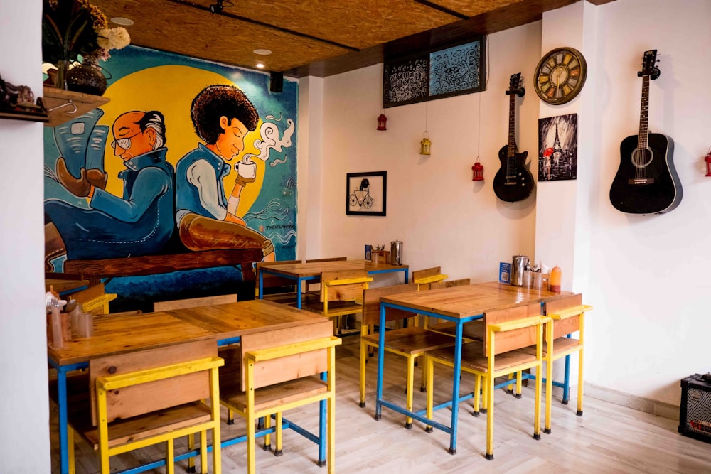 a room with many tables and chairs and a mural on the wall
