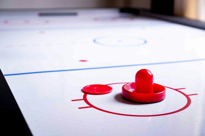 Close view of a hockey puck sitting on the ice near a faceoff circle
