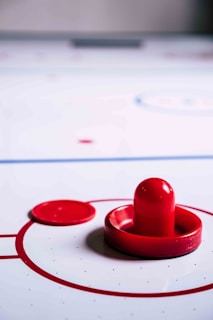 A lively scene of friends playing air hockey with fast puck movement.