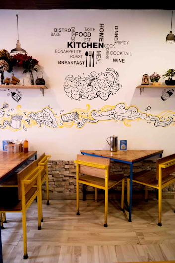 a restaurant with yellow chairs and wooden tables