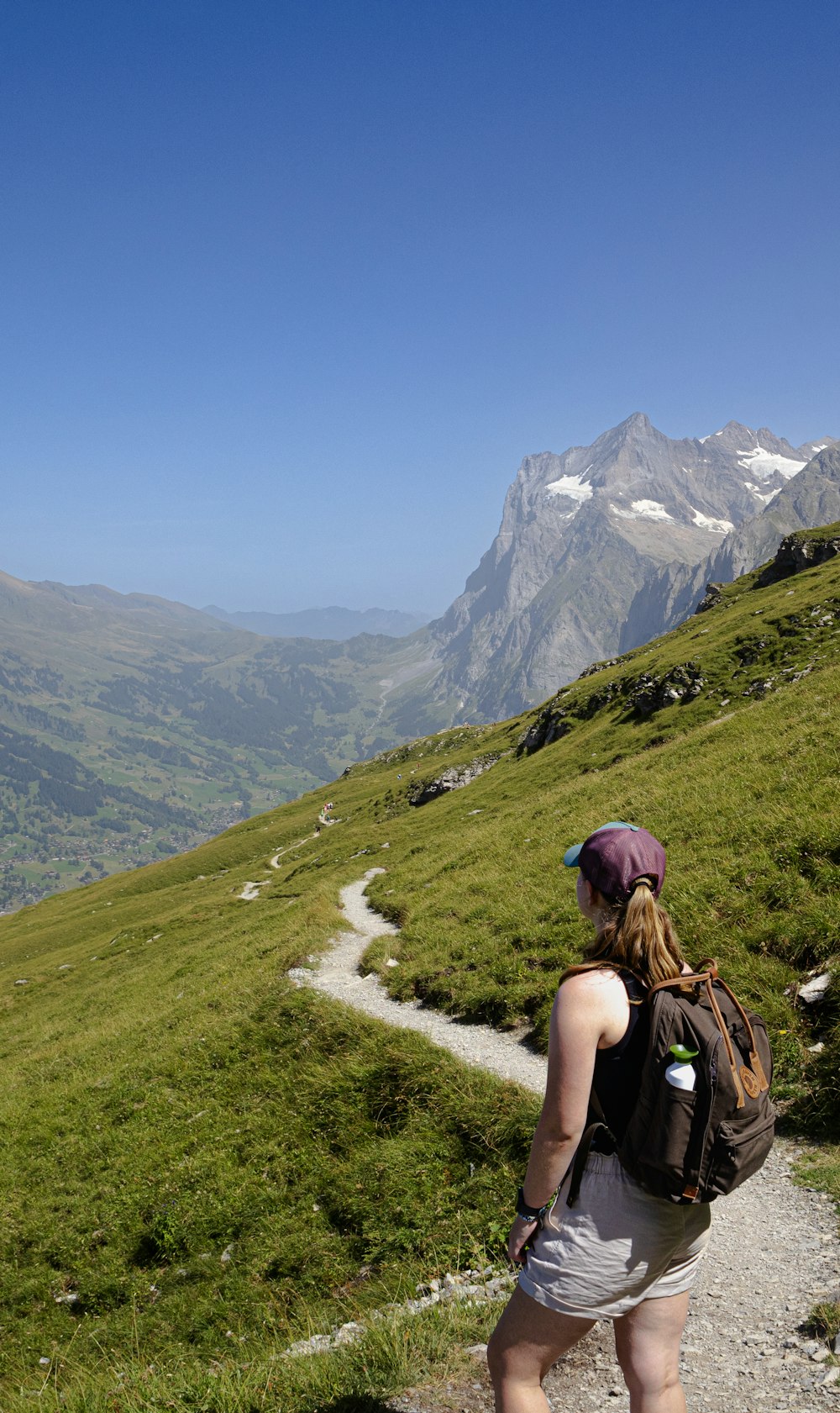 a woman with a backpack walking up a hill