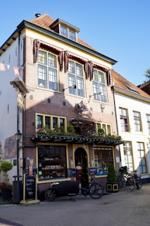 A charming brick storefront in historic downtown Asheville with large display windows.