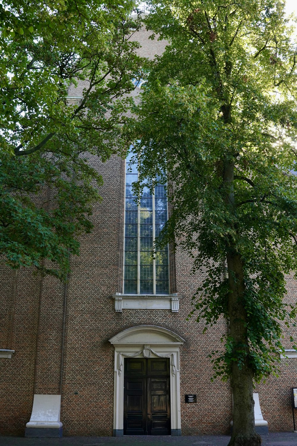 a tall brick building with a tree in front of it