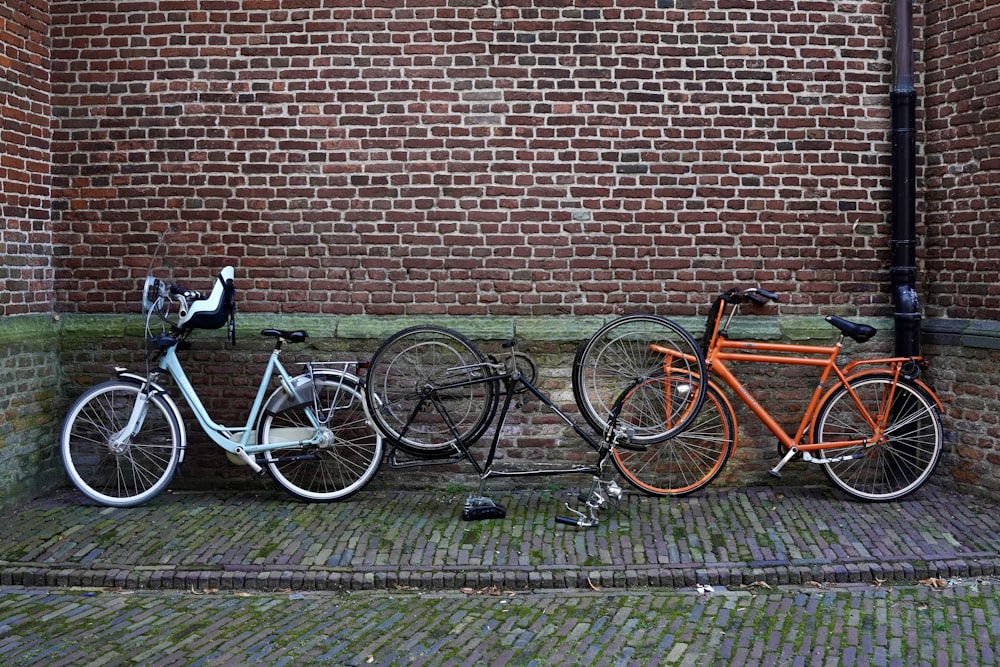 a couple of bikes parked next to a brick wall