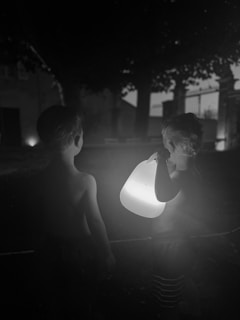 Children and parents walking along the eerie yet inviting haunted path lined with glowing lanterns
