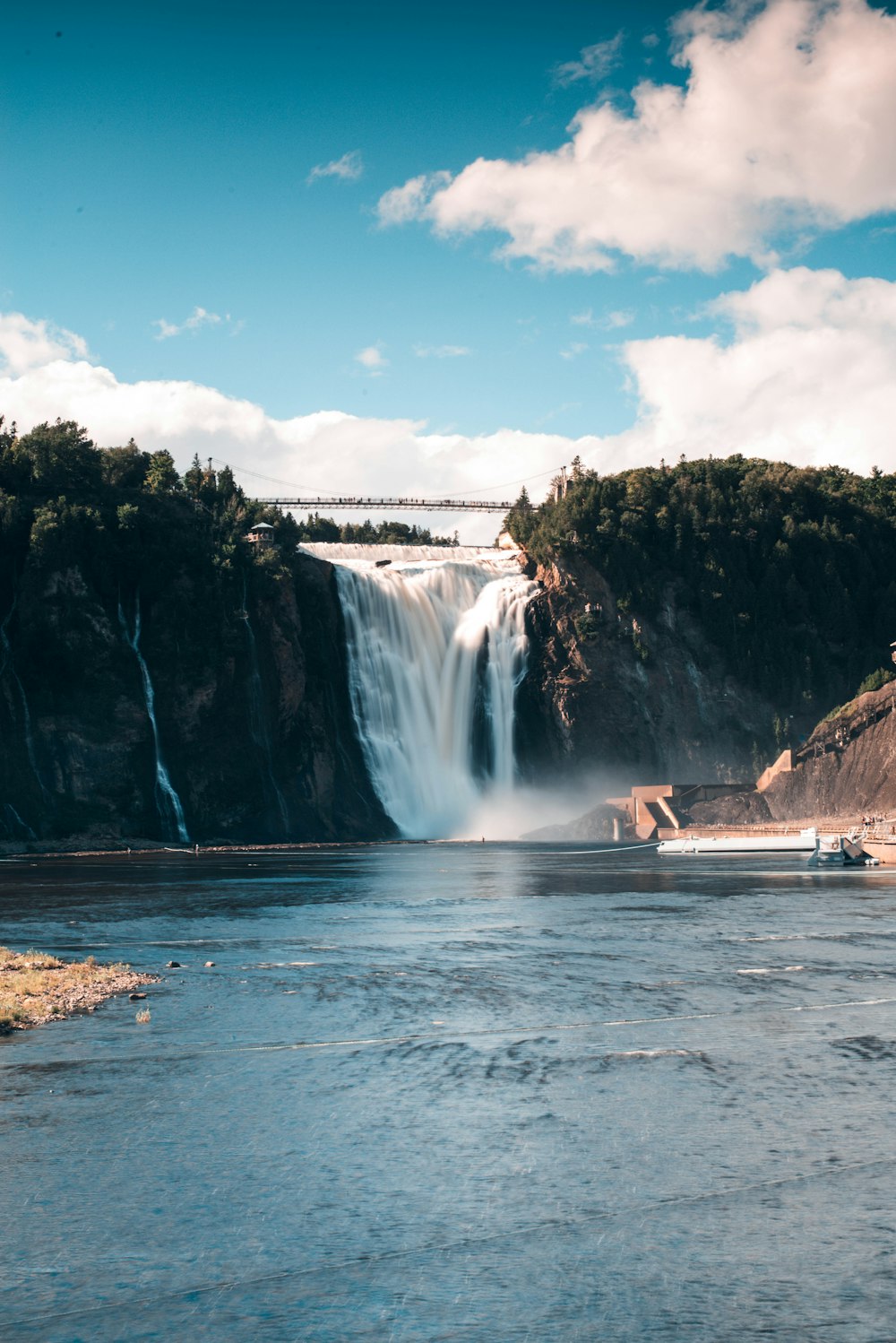 a boat is in the water near a waterfall