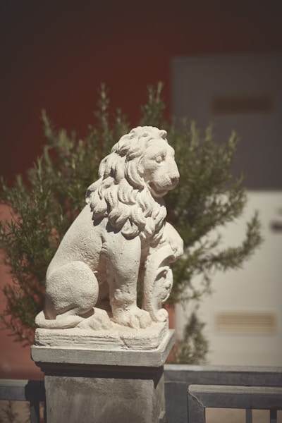 a statue of a lion sitting on top of a cement block
