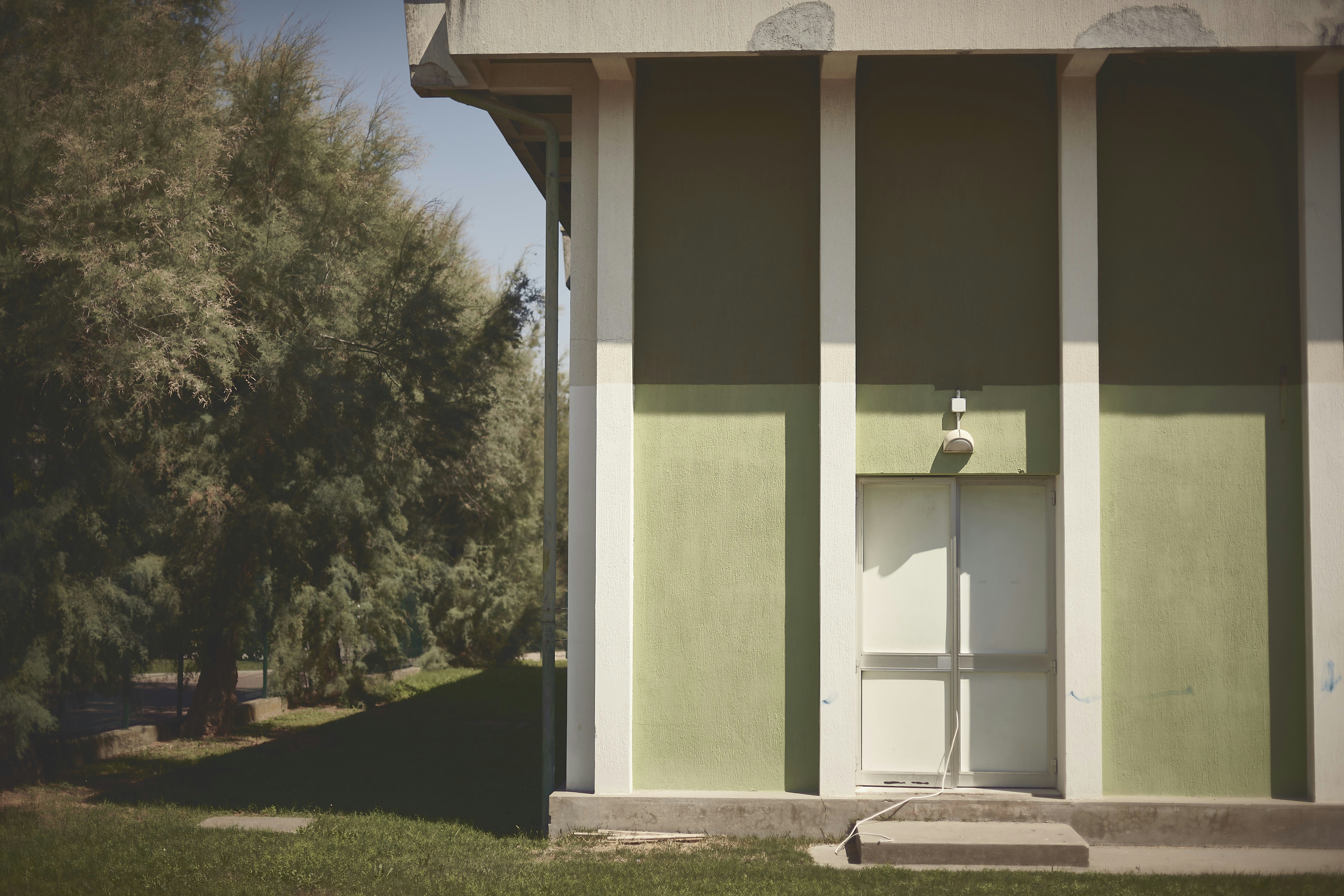 a green and white building with a white door