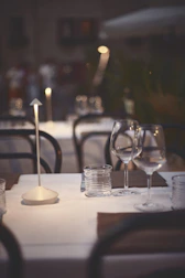 An intimate dining table set outdoors with elegant plates of plant-based cuisine under soft lighting.