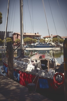 A certified naval architect inspecting the hull of a sailboat on a sunny dock.