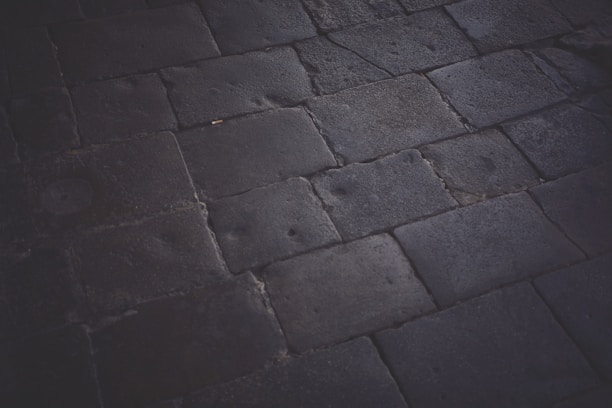 Close-up of a smooth, elegant stone driveway with clean lines and subtle lighting.